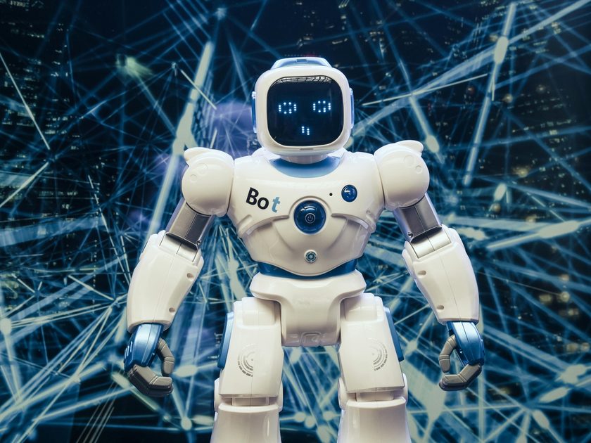 Toy robot standing in front of a digital network graphic